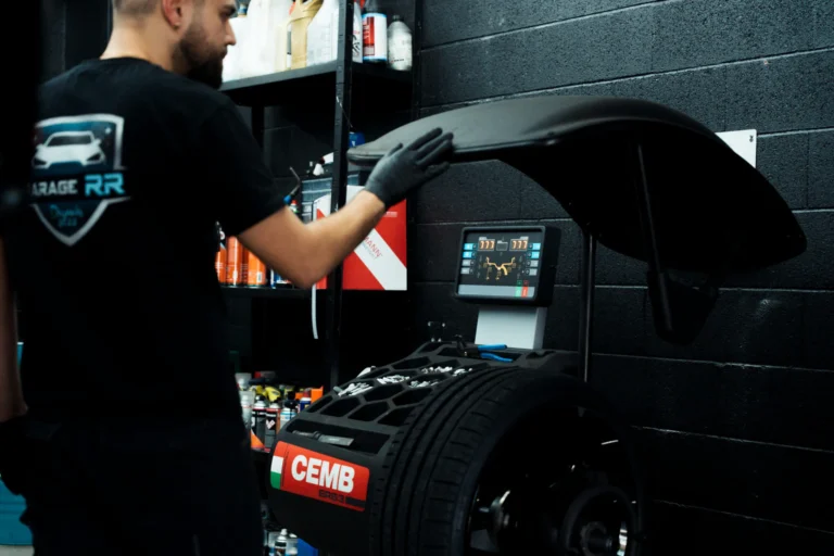Technicien utilisant la machine d'équilibrage Cemb au Garage RR Ecublens